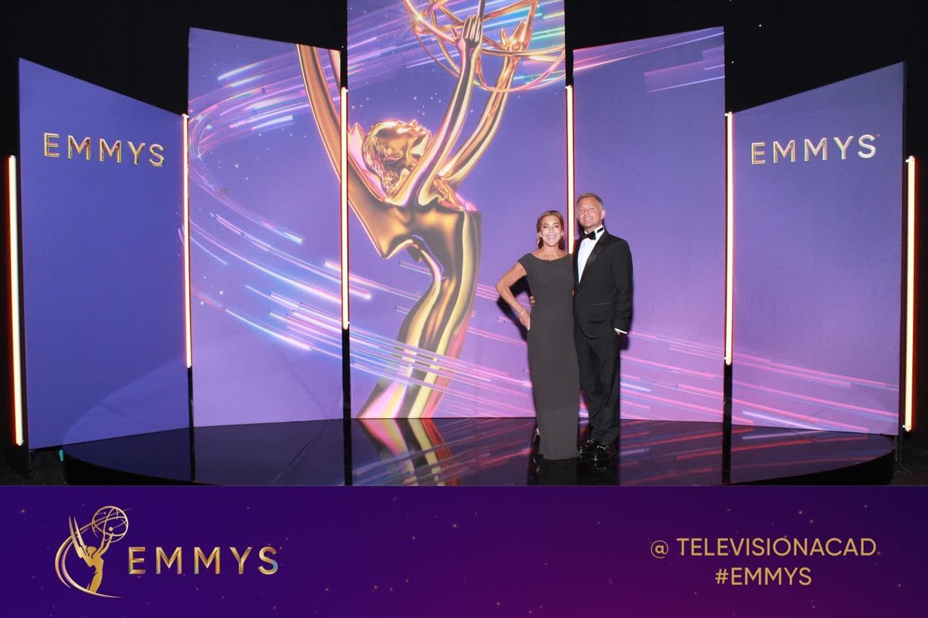 Barry and Claudia Poznick photographed in front of the Emmys statuette stage backdrop